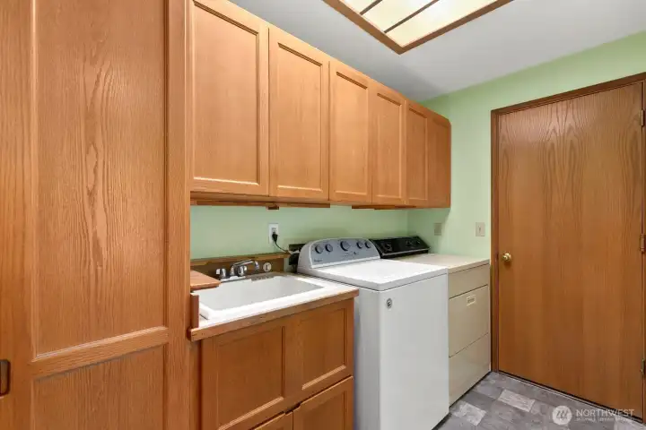 Laundry room with storage sits off entry to attached 2 car garage.
