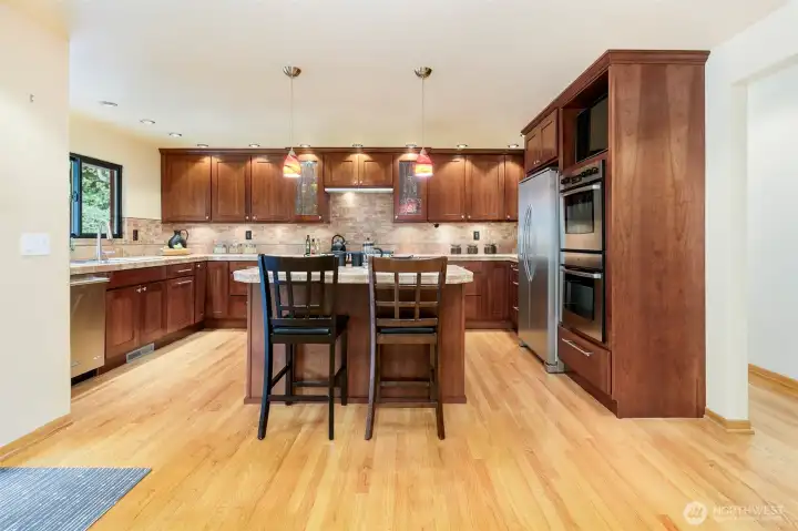 Remodeled gourmet kitchen with large island, gas range, and double ovens in Broadview Seattle home.
