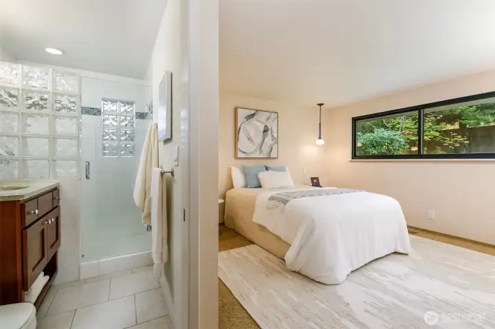 Primary suite with large windows and garden views in Broadview rambler.