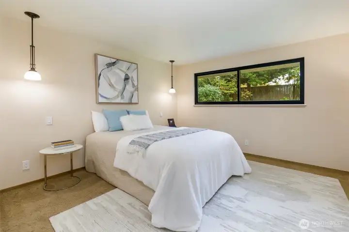 Primary suite with large windows and garden views in Broadview rambler.