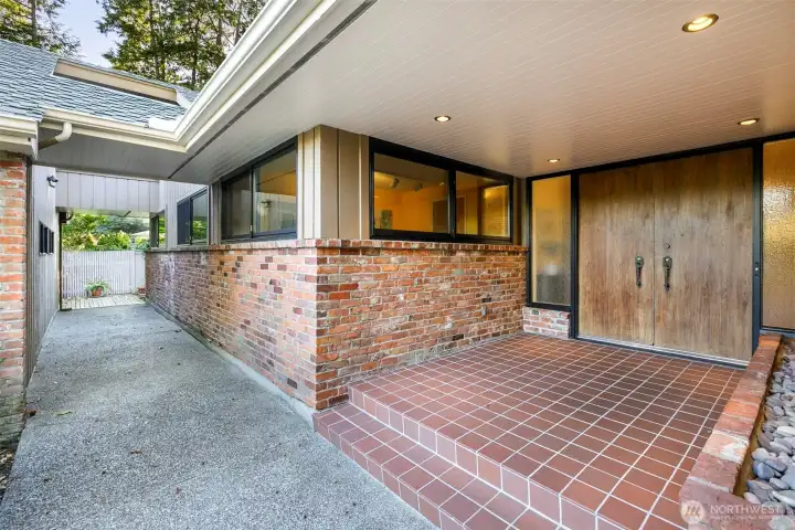 Gracious courtyard entry of Broadview rambler with brick walkway and garden views.