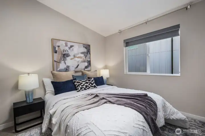 Spacious primary bedroom with vaulted ceilings.