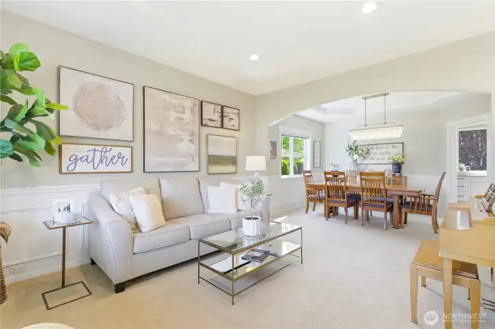 The formal living room showcases wainscoting and distinctive architectural details.