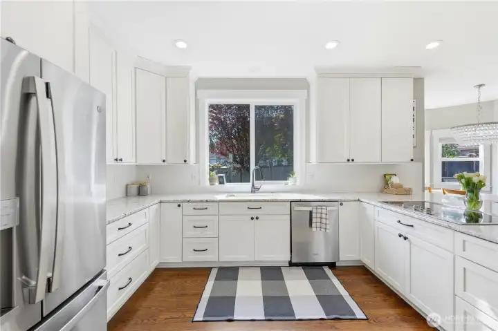 From the dining room, step into the updated kitchen with white cabinetry, newer stainless appliances, and granite countertops.