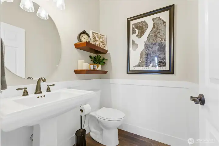 A tastefully updated powder room on the main features new tile flooring.