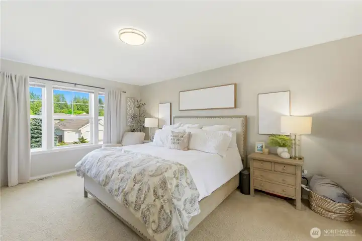 The serene primary bedroom is spacious enough for a king-sized bed and additional furnishings.