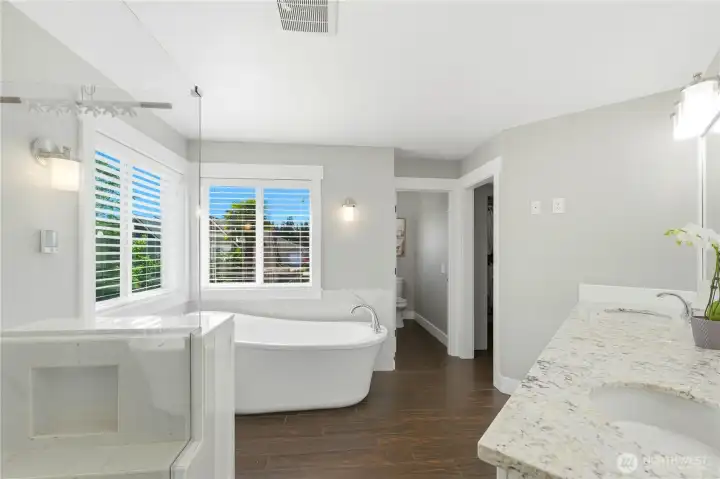 The primary bath features a soaking tub, dual sinks, tile floors, a beautifully tiled shower, tile flooring, separate water closet, and a large walk-in closet with organizers.