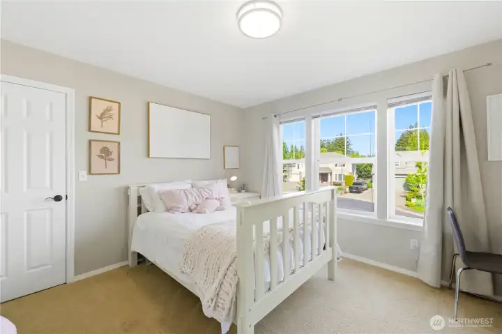 The third bedroom offers a large window and a walk-in closet.