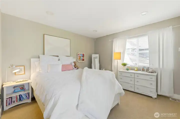 The fourth bedroom features large windows, a built-in desk, and a well-sized closet.