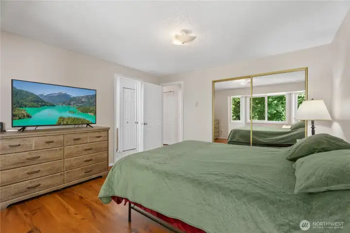 The spacious primary bedroom offers a serene retreat with large windows and plenty of space for a king sized bed.