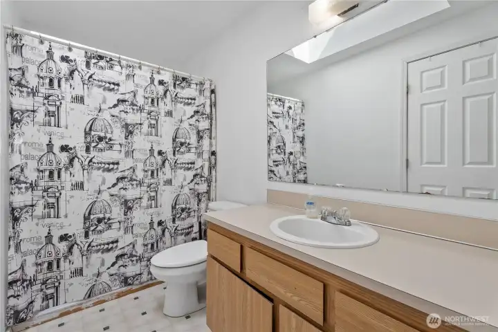full bathroom complete with a spacious vanity.