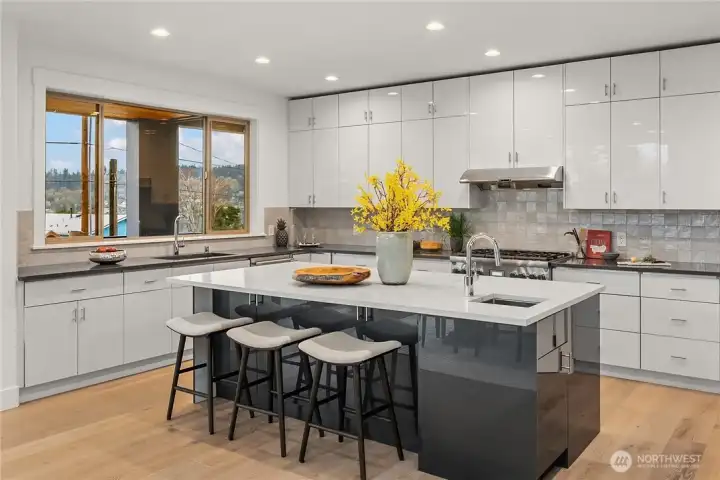 Dream kitchen w/oversized island, SS appliances + wraparound deck w/Lake WA views
