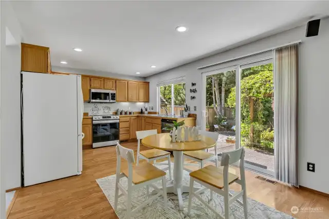 Sunny kitchen overlooks a lush and private backyard and includes all appliances.