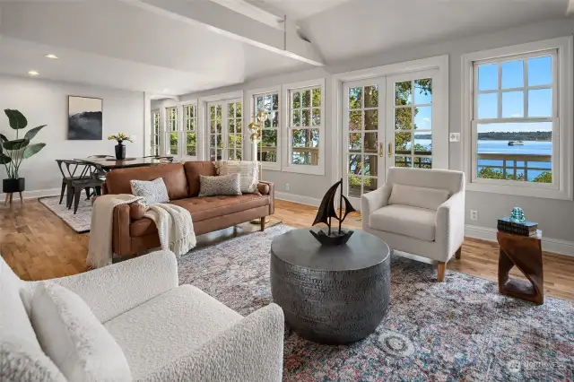 The living/dining room enjoys many windows and French doors to the deck.