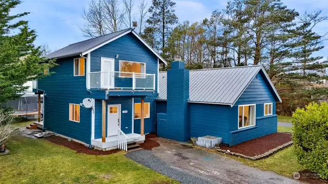 Welcome to 2155 Postal Avenue in Gooseberry Point, Bellingham, WA! This beautifully updated home features a bold blue exterior, a durable metal roof, and a charming balcony. Nestled on a private 0.67-acre lot, it is surrounded by mature trees, offering peace and serenity.