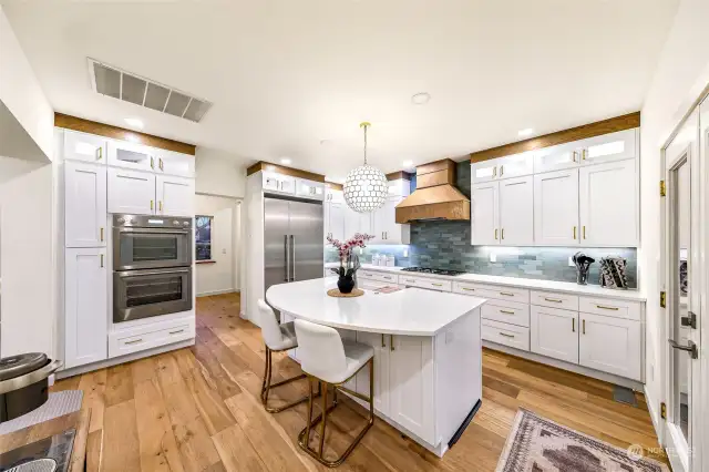 A secondary angle of the kitchen highlights the custom cabinetry, double ovens, and built-in refrigerator. The open layout ensures convenience and flow while cooking or entertaining.