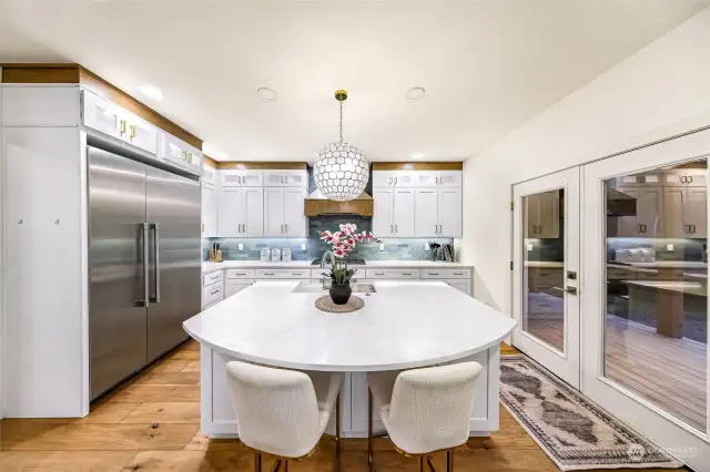 The expansive island in the kitchen offers both functionality and design. With seating for two and a view into the open-concept dining area, it’s perfect for casual meals or conversation.