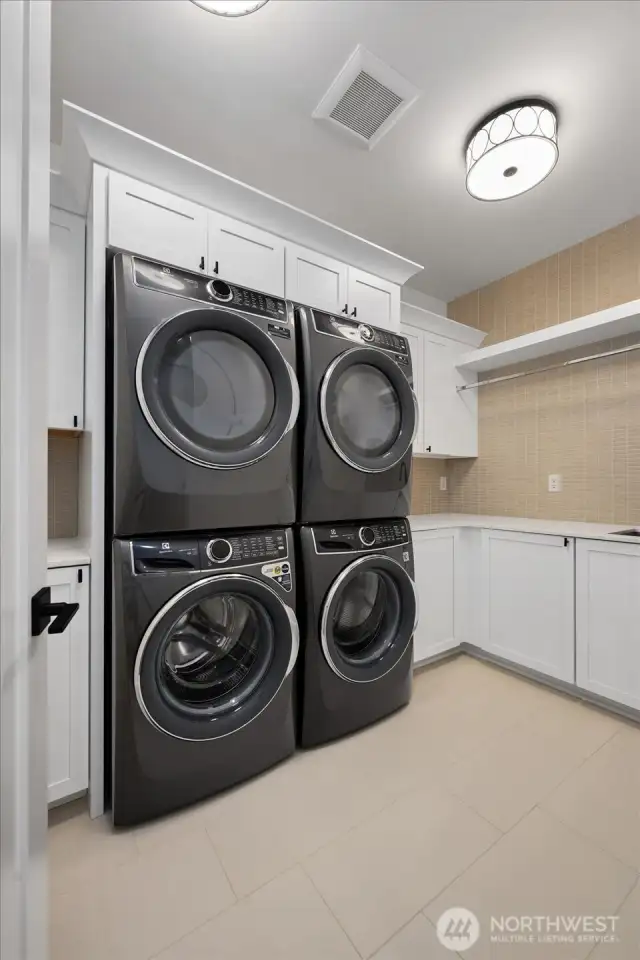 laundry room with 2 sets of washer & dryers