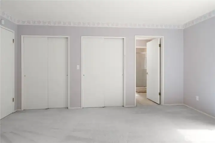 Primary Bedroom facing 2 of 4 closet spaces and bathroom entry. Entry door is on the left.