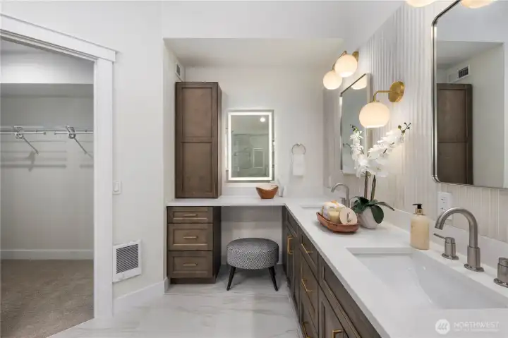 Vanity space with backlit mirror and additional storage.