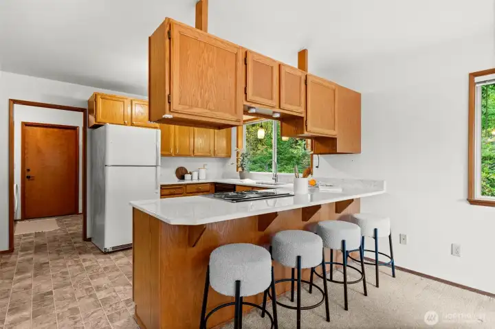 An extended countertop in the kitchen provides extra seating for casual dining or conversation.