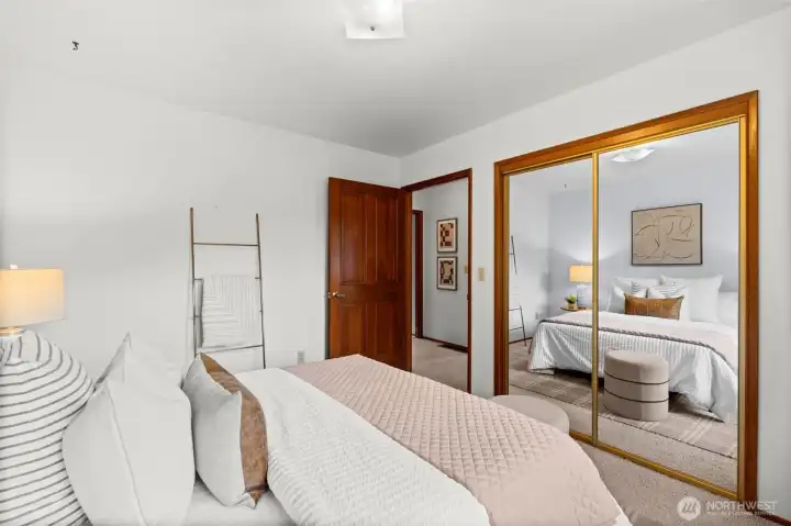 Mirrored closet doors enhance the sense of openness and add depth to the room.