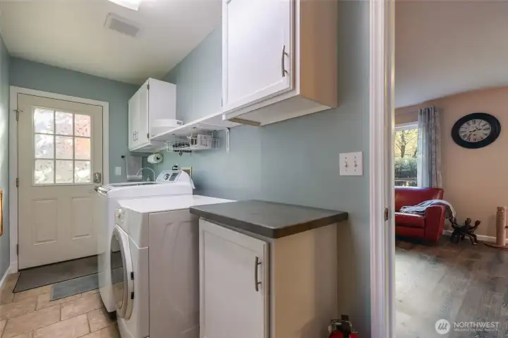 Laundry room and door leading to side yard. To the left is the garage entrance.
