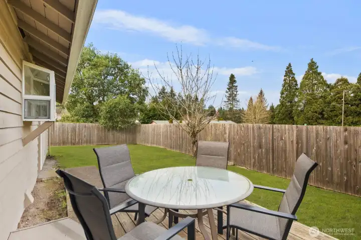 Fully fenced backyard featuring a patio area, level lawn, and space for outdoor dining