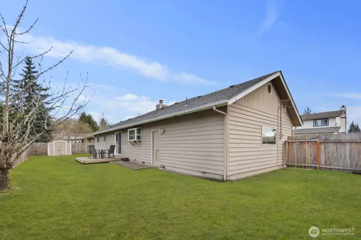 Generous backyard with patio deck, lawn space, and perimeter fencing