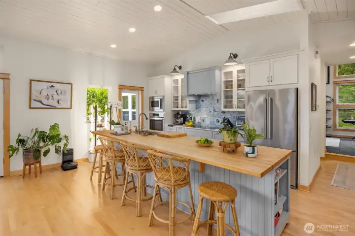 The kitchen features a large butcher block wood  counter- perfect gathering with friends while you are cooking.