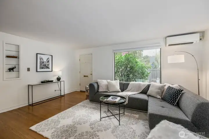 Enter into the main living area... with gorgeous hardwood floors... large window for lots of natural light and mini-split heat/ac unit!  Notice the vintage built-ins...