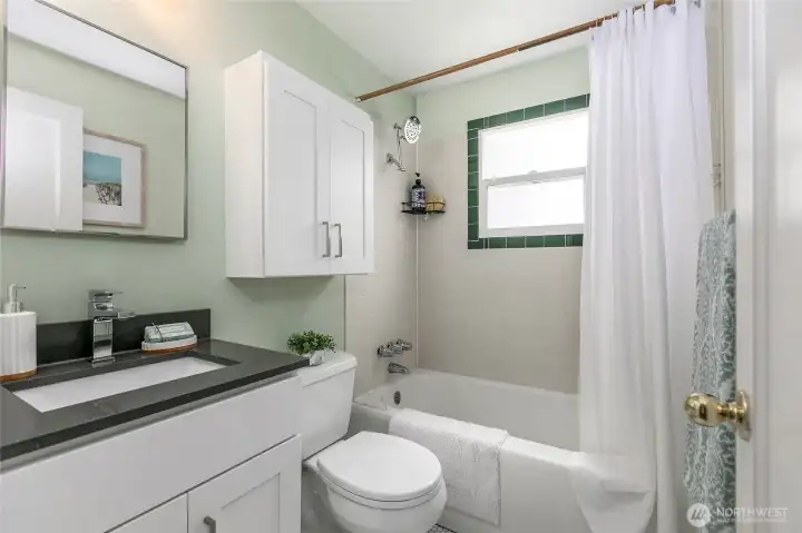 The bathroom has been updated with new tile floors, tub surround and vanity....