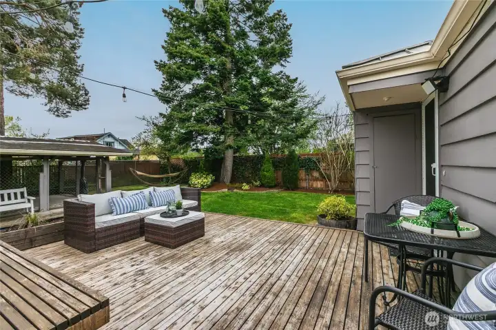 Head out from the kitchen to this entertainment size deck...  perfect for relaxing with your favorite beverage or for outdoor entertaining. Notice the covered patio in the background... It is currently fenced in and was used by previous owners for a dog run.