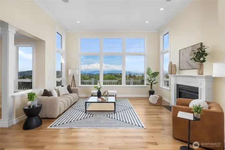Open living room with a cozy fireplace, 14' ceilings and floor to ceiling windows to frame the amazing views.