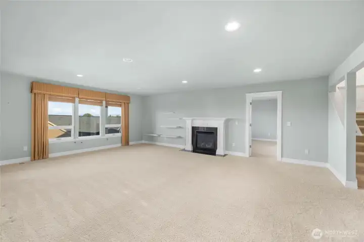 Lower family room has a cozy fireplace and deck access.