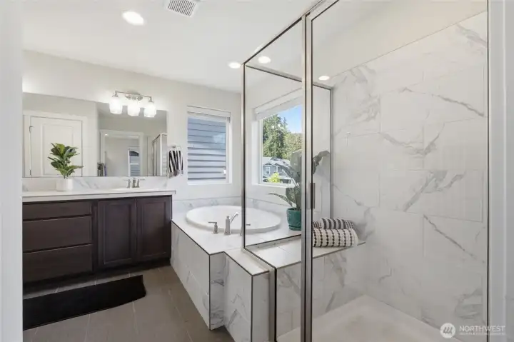 A spa-inspired ensuite features a walk-in shower, soaking tub, and timeless finishes.