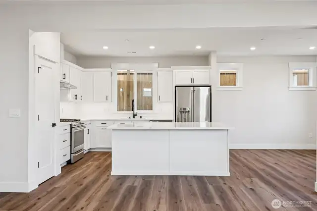 Generous kitchen island with adjacent pantry.