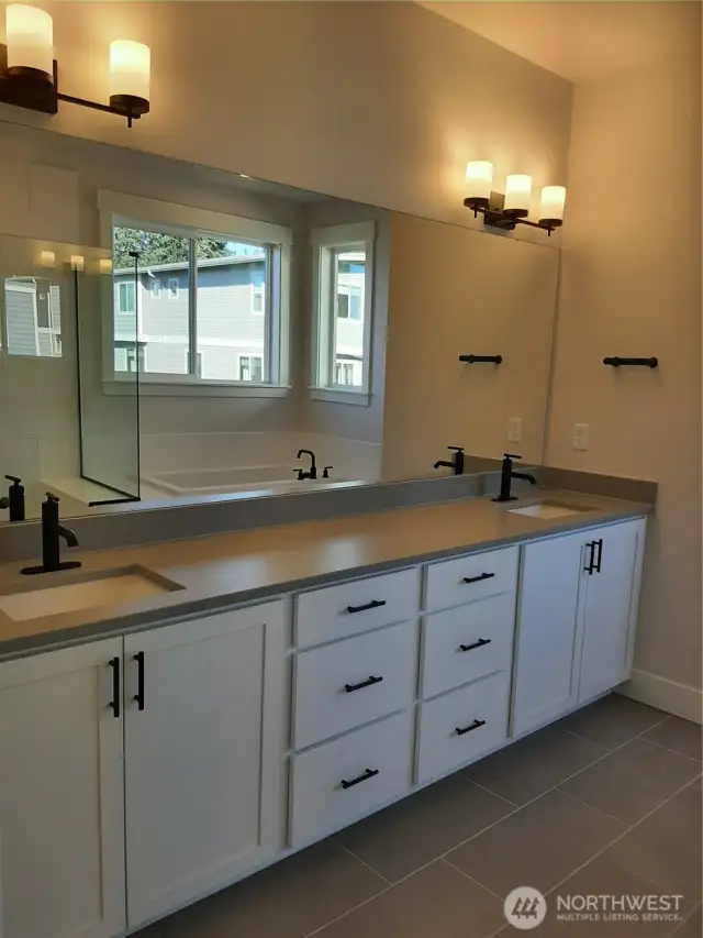 Expansive primary bath vanity, highlighted by quartz counters and ample storage.