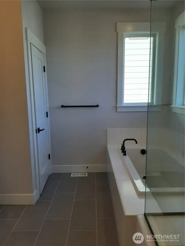 Relax in the primary bath soaking tub adjacent to the private toilet closet