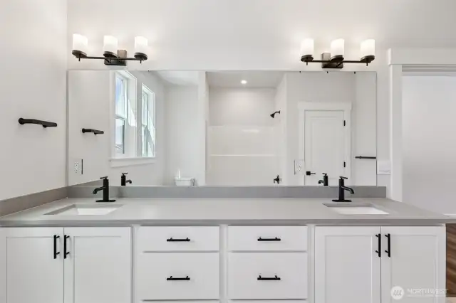 Hall bath dual vanity showcases upgraded matte black hardware finishes which are throughout the home.