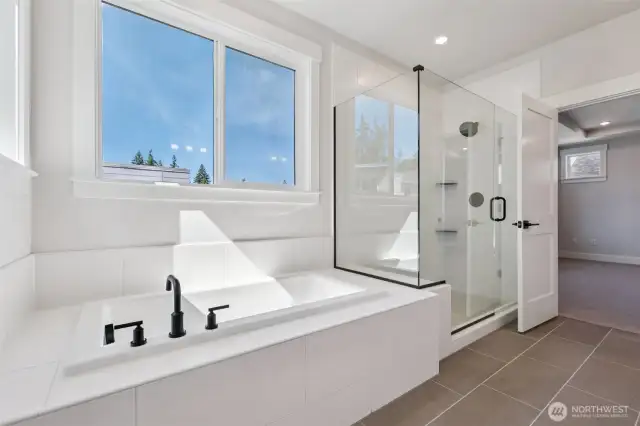 Inviting soaking tub and glass shower in primary bath.