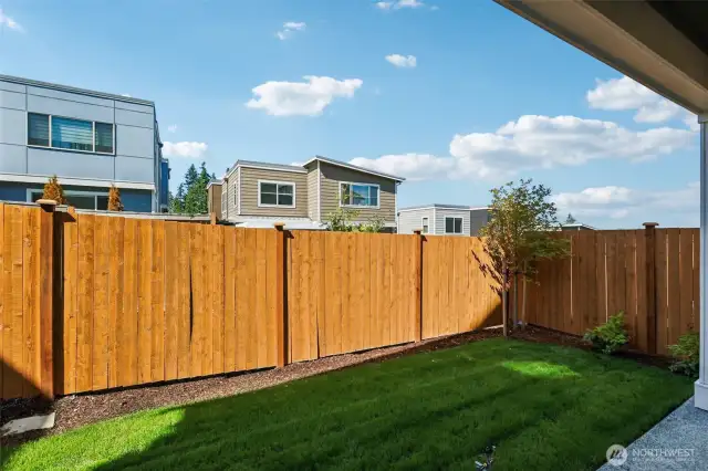Covered patio overlooks fully landscaped and fenced rear yard.