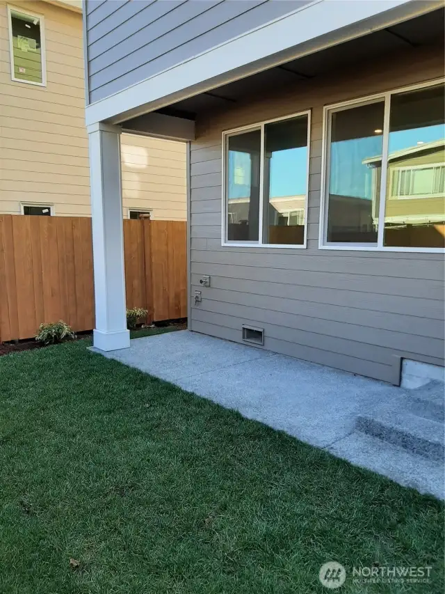 Covered patio overlooks fully fenced and landscaped rear yard, a perfect private oasis.