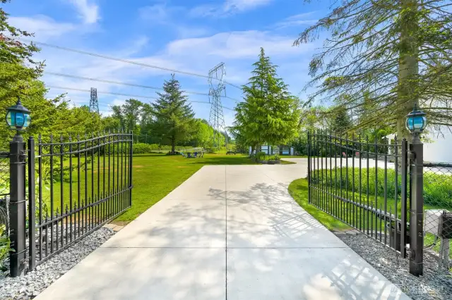 Black iron fencing and coded power gate create an elegant entrance to the property