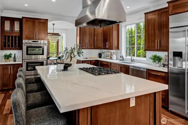 Designer Quartzite stuns in this gorgeous luxury kitchen with an abundance of features! State-of-the-Art appliances for the discerning host including Fisher & Paykel double ovens and dishwasher drawers, 6-burner range with dramatic stainless hood and large single basin sink with retractable brushed nickel faucet and modern hardware elevate this space.