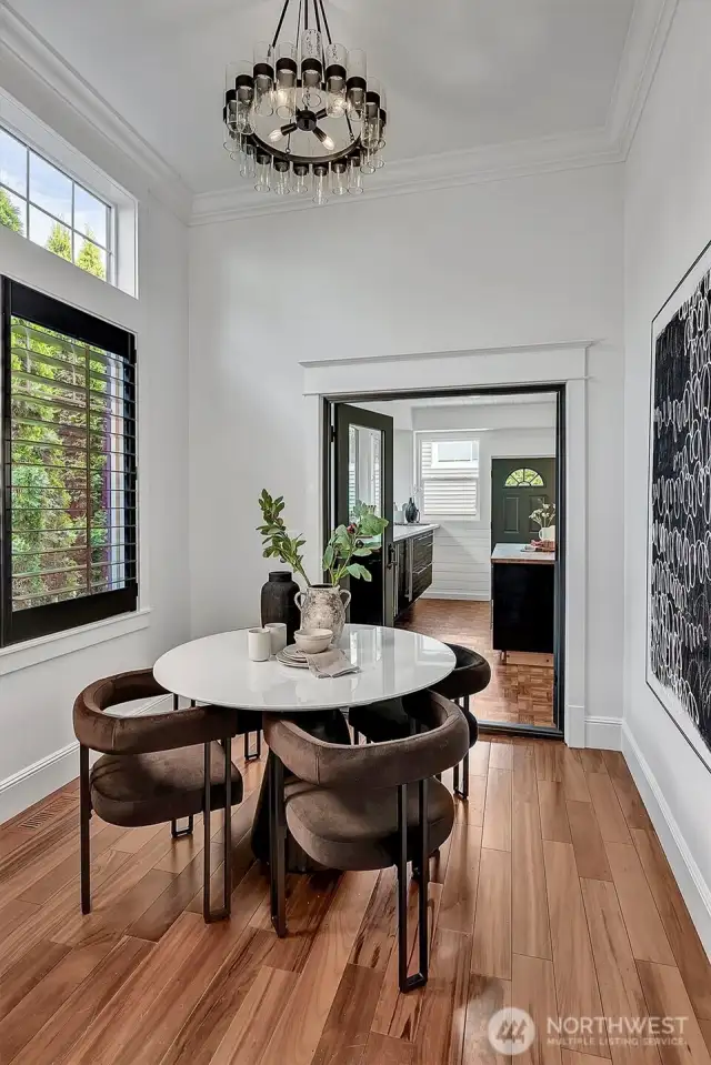 Sky high ceilings in this cozy breakfast nook with custom built-in shelf and high-end designer lighting!