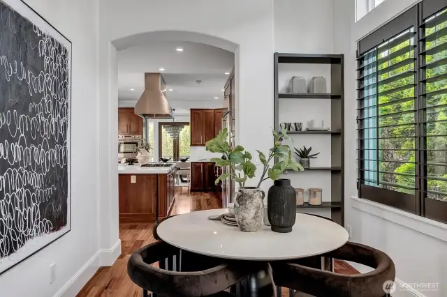 Sky high ceilings in this cozy breakfast nook with custom built-in shelf and high-end designer lighting!