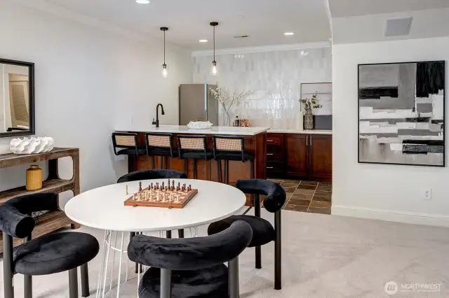 An entertainer’s dream, this exquisite full bar is the heart of the lower level! Stunning light and bright quartzite counters create a striking focal point, while curated tiling adds a touch refinement.