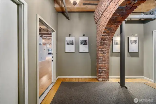 Foyer of floor 3. Unifying artwork. Original fir floors and exposed brick.