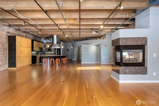 Open floorplan with fir floors, open beamed ceiling, double-sided gas fireplace, steam heating.